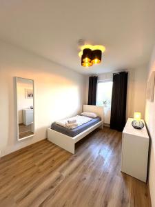 a bedroom with a bed and a mirror in it at Balance Apartments by M&A Train Station Business in Witzenhausen