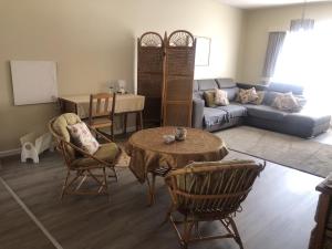 a living room with a couch and a table and chairs at Sonneneck 7 in Swakopmund