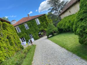a house with a gravel driveway in front of a yard at LA SEIGNEURIE DE TILLAC in Tillac