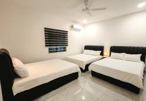 a bedroom with two beds and a ceiling fan at Soga Homestay 6 Rooms 4 Baths New House in Batu Pahat