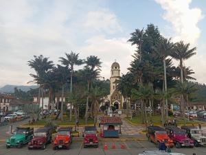 a group of cars parked in front of a building with a clock tower at Paisaje Andino Salento in Salento