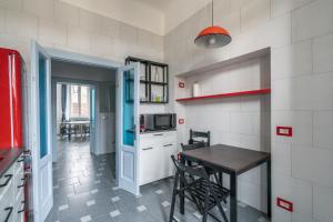 Una pequeña cocina con una mesa y un microondas. en Appartamento Plinio, en Milán