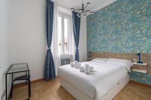 Un dormitorio con una cama grande con una pared azul. en Appartamento Plinio, en Milán
