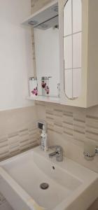 a bathroom with a white sink and a mirror at La Casa di Giò in Taormina