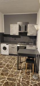 a kitchen with a stove and a table in it at La Casa di Giò in Taormina