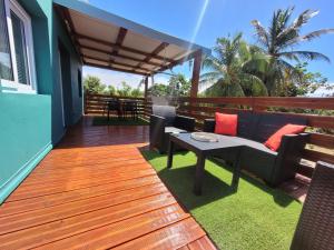 a wooden deck with a table and chairs on it at Ti cocon nature in Sainte-Anne