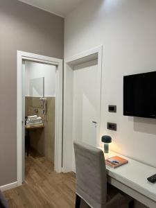 a room with a desk with a chair and a television at Olivia Rooms Eurialo in Belvedere +9 photos
