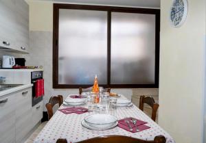 a kitchen with a table with plates and glasses at Intera casa indipendente vicino al centro di Catania in Catania