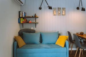 ein blaues Sofa mit gelben Kissen in einem Zimmer in der Unterkunft Luxury cabins with own sauna and hot-tub in Ķesterciems