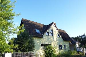 a white house with a black roof at Ferienwohnung am Berliner Stadtrand in Berlin