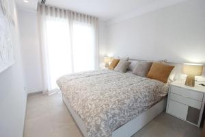 a white bedroom with a bed and a window at Villa Almendro Santa Rosalia Lake and Life Resort by PREMIUM SPAIN PROPERTIES in Torre-Pacheco