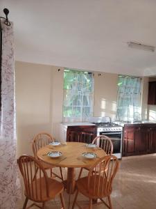 a kitchen with a wooden table and chairs at Peppy's Palace in Roseau