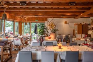 a restaurant with white tables and chairs and windows at Hotel Il Castagno in Mugena