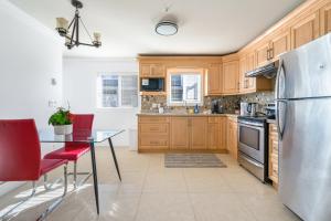 a kitchen with wooden cabinets and a stainless steel refrigerator at Spacious and Modern Comfort Retreat in Heart of Vancouver in Vancouver