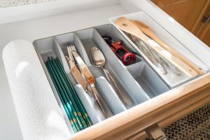 a drawer filled with utensils in a drawerlictsangering at Spacious and Modern Comfort Retreat in Heart of Vancouver in Vancouver +9 photos