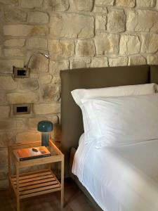 sypialnia z łóżkiem i stołem z lampką w obiekcie Olivia Rooms Eurialo w mieście Belvedere