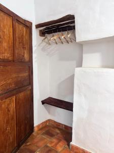 a closet with a wooden door and wooden hangers at Habitación Vanessa, una ó dos personas in Barichara