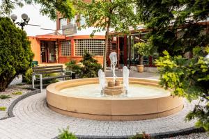 a fountain in a courtyard in front of a building at Restauracja Hotel VIP in Działoszyn