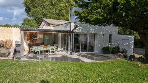 a small house with a patio with a table at La Palombe in Saint-Macaire