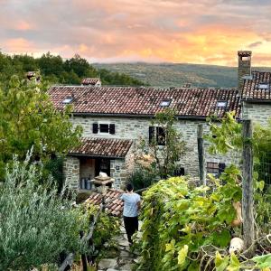 un hombre caminando hacia una casa de piedra en Bolara 60: the Cottage, en Grožnjan