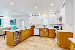 a kitchen with white cabinets and wooden floors at Blue Shores in Port Richey