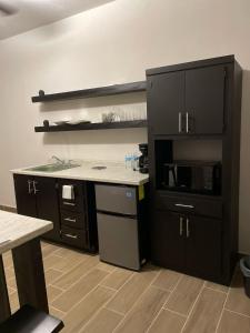 a kitchen with black cabinets and a microwave at LiV109 Norte Depa 4 Cd Obregon in Ciudad Obregón +20 photos