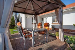 ウッカーミュンデにあるFerienbungalow Meerjungfrauのパティオ(パラソルの下にテーブルと椅子付)