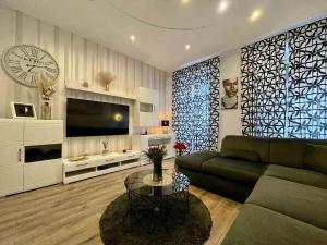 a living room with a couch and a clock at Holiday home in Crikvenica 5589 in Crikvenica