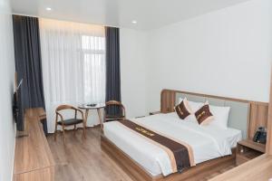 um quarto com uma cama grande e uma mesa em Long Hải Hotel em Móng Cái