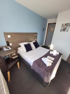 a hotel room with a bed with towels on it at Hotel Logis Au Moyne de Saire in Réville