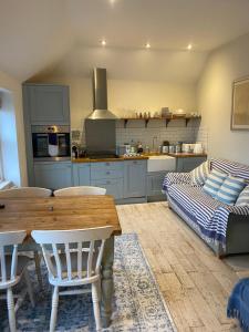 a kitchen with a wooden table and a couch at Little Dolly sea view 2 bedroom apartment, St Ives town, dog friendly in St Ives