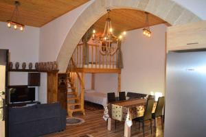 a living room with a dining room table and a staircase at michaelas traditional house in Fánai