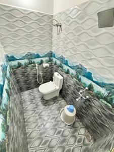 Un baño con inodoro y un cuadro en la pared. en Le Oasis Auro'Ra, en Pondicherry 65 fotos más
