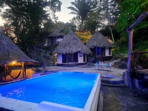 ein Resort mit einem Pool und Hütten in der Unterkunft Tawaca Ecohotel in Calabazo