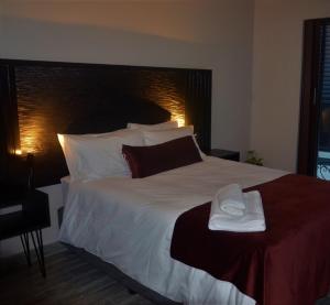 une chambre avec un grand lit avec des draps et des oreillers blancs dans l'établissement 9 Serendipity Stay, à George