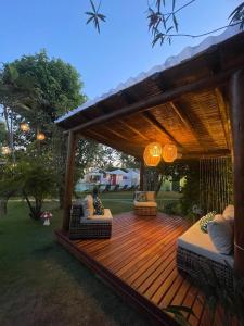 a wooden deck with couches and a pergola at Pousada Le Baron in Praia do Frances