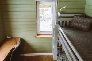 ein Schlafzimmer mit grünen Wänden und einem Etagenbett mit Fenster in der Unterkunft Luxury cabins with own sauna and hot-tub in Ķesterciems + 63 Fotos