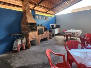 ein Wohnzimmer mit einem gemauerten Kamin sowie einem Tisch und Stühlen in der Unterkunft Chalé do vó in Caldas