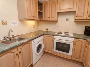 a kitchen with a sink and a washing machine at The Smithy in Wooler