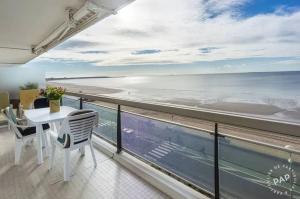 a balcony with a table and chairs and the ocean at Appartement avec vue sur la mer à La Baule 62 m² tout équipé in La Baule