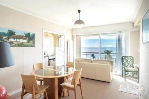 a living room with a couch and a table and chairs at Appartement avec vue sur la mer à La Baule 62 m² tout équipé in La Baule