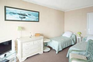 a hotel room with a bed and a tv and a bed and a chair at Appartement avec vue sur la mer à La Baule 62 m² tout équipé in La Baule