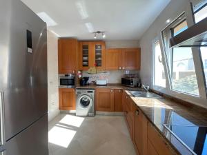 a kitchen with wooden cabinets and a washer and dryer at Villa Bonita in Corralejo