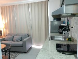 a living room with a couch next to a kitchen at cr.arenalapartments#3 hermoso lugar con parqueo in Fortuna