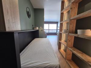Bett in einem Zimmer mit Holzregalen in der Unterkunft ROCH B300 - Magnifique studio - Centre Bourg Saint Maurice in Bourg-Saint-Maurice