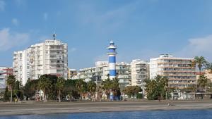 eine Stadt mit einem Leuchtturm vor einigen Gebäuden in der Unterkunft Apartamento 2 habitaciones frontal al mar 3 in Torre del Mar