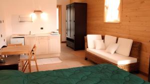 a living room with a couch and a table and a kitchen at Agriturismo Prisma in Villa Vergano
