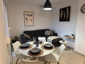 a living room with a table and chairs and a couch at Apartman Ema in Opuzen