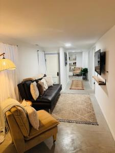 un soggiorno con divano in pelle nera e TV di The Avondale Retreat a Chicago