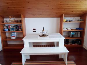 Una pequeña mesa blanca con una botella de vino. en Mundaka Vista Mar L-BI-52, en Mundaka